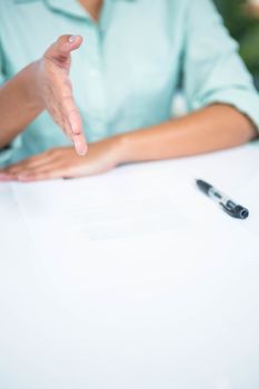 Mid section of a businesswoman ready to shake hand in office