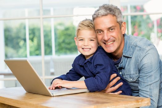 Father and son using laptop at home