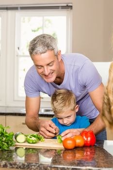 Happy family slicing vegetables in the kitchen