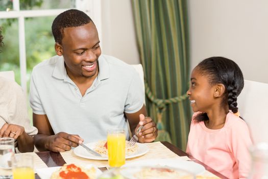 Happy family enjoying their meal at the dinner table