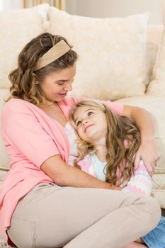 Mother and daughter smiling together by the couch