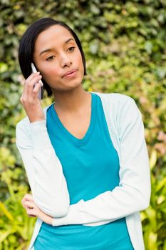 Serious brunette on a phone call outdoors