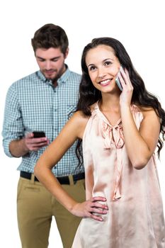 Smiling couple using smartphones on white screen