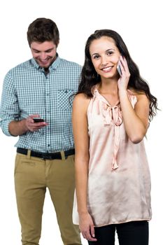 Smiling couple using smartphones on white screen