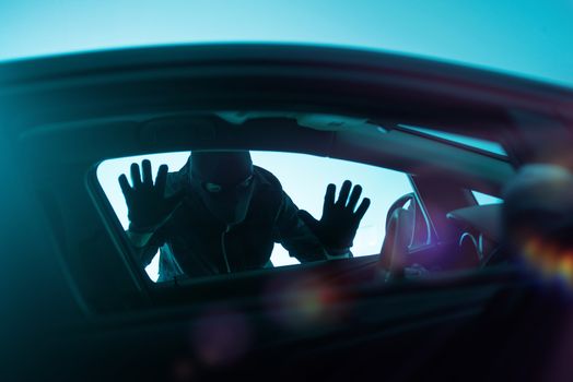 Car Robber Concept Photo. Robber Looking Thru Car Window. Carjacking Theme.