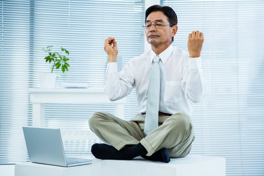 Peaceful asian businessman relaxing in office
