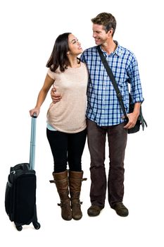 Cheerful couple with luggage standing against white background