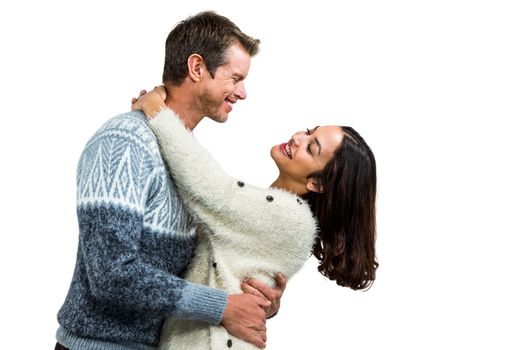 Romantic couple embracing in warm clothing against white background