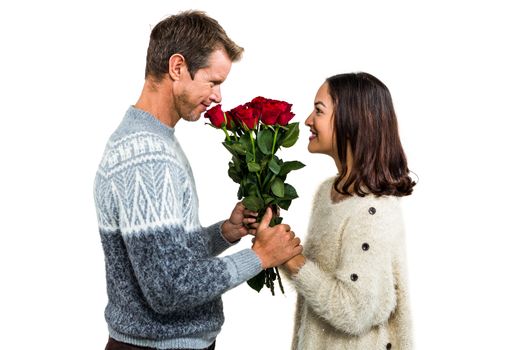 Romantic couple holding red roses against white background