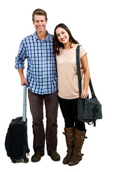 Full length of cheerful couple with luggage standing against white background