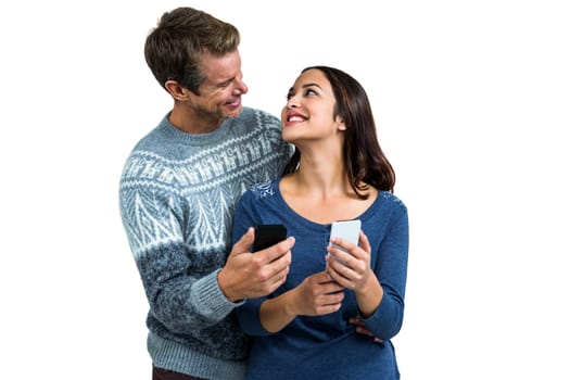 Happy romantic couple with mobile phone standing against white background