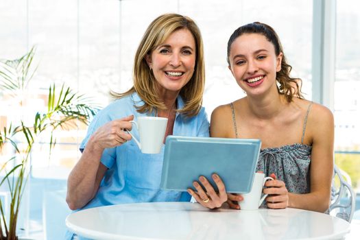 Mother and daughter watch tablet in the kitchen