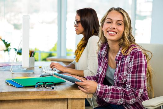 Two girls use a computer in an office