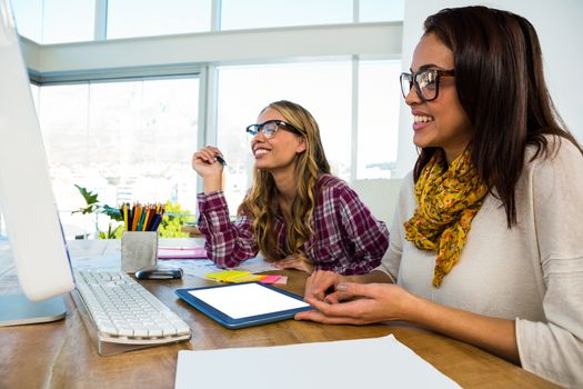 Two girls work at office on computer and tablet