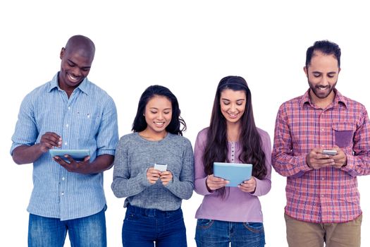 Happy multi-ethnic friends using technologies while standing against white background