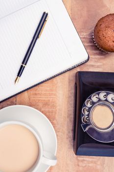 Close-up of coffee with old land line and book on table