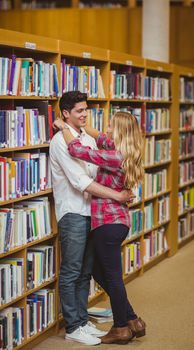 Student couple embracing each other in library