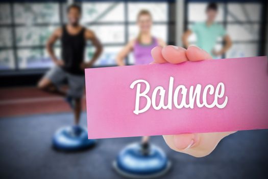 The word balance and young woman holding blank card against 