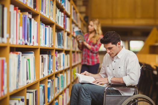 Student in wheelchair talking with classmate in library