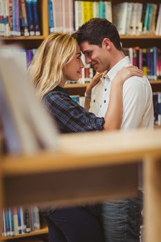 Couple with books looking at each other in the library