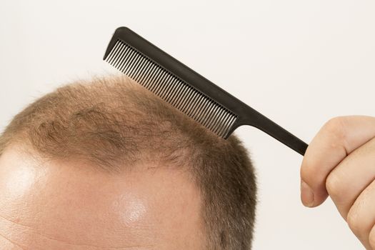 40s man with an incipient baldness doing hair with background