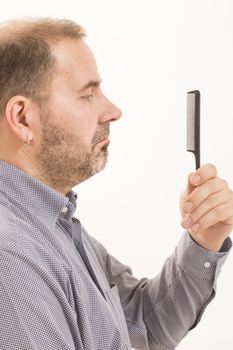 40s man with an incipient baldness, doing hair with a comb