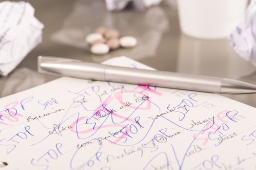 Office workplace with book, crumpled paper, pen,  on grey desk