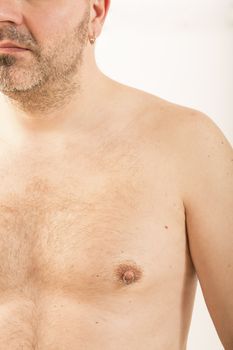 Close up of muscular male torso with a nipple piercing