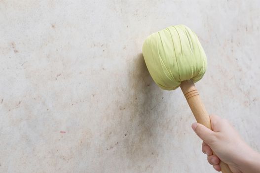 Hand of woman hold green and wooden drumstick hit on battle drum.