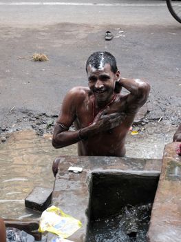 Streets of Kolkata. Indian people wash themselves on a street , January 25, 2009.