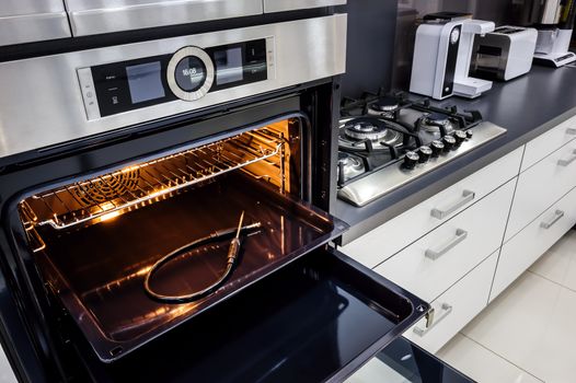 Modern luxury hi-tek black and white kitchen, clean interior design, focu at oven with door open