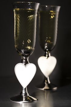 Champagne and valentines day decoration on black glitter background, love