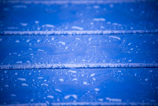 blue wooden planks with water and rain drops on the surface