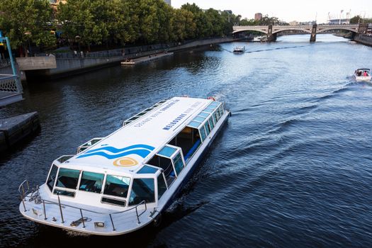 A popular tourist boat cruising under the Princess Bridge on Melbourne's Yarra River.