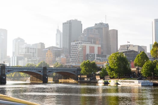 An image of Melbourne's Princess Bridge with the Yarra River in the forground and tourist boats and highrises in the background.