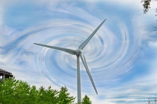 Single wind turbine in front of abstract dramatic blue sky and cloudscape.