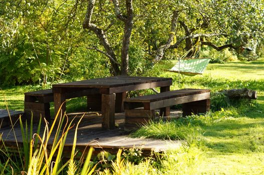 Wooden table bench hammock in garden