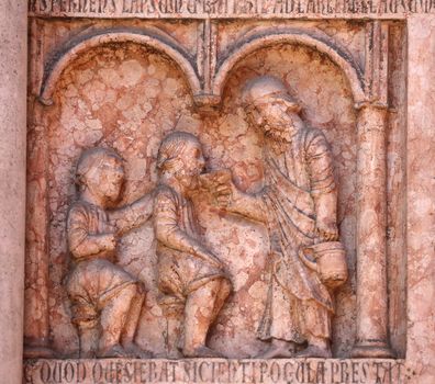 Christ Performing Works of Mercy relief at the baptistry from Benedetto Antelami, Parma, Emilia Romagna, Italy