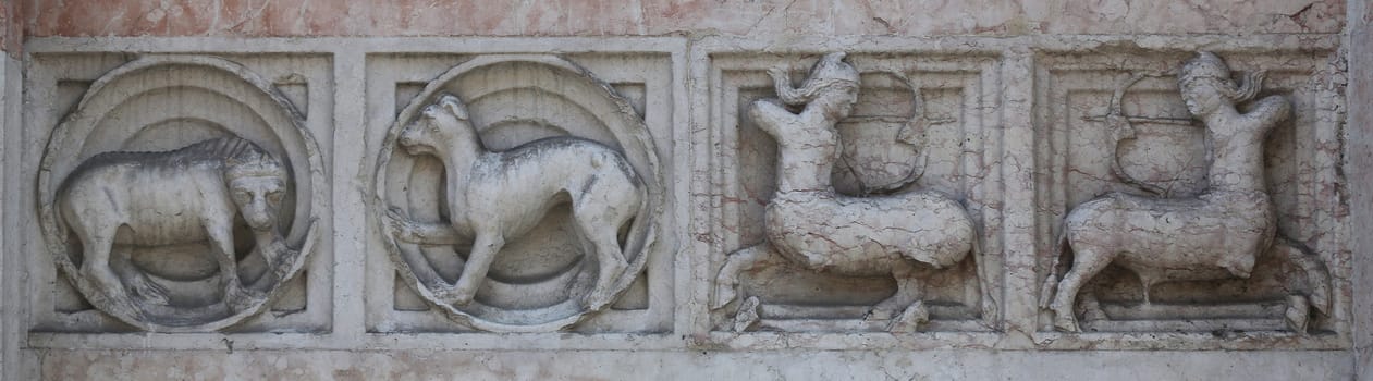 Detail of some marble medieval bas relief outside the Baptistery in Parma, Italy