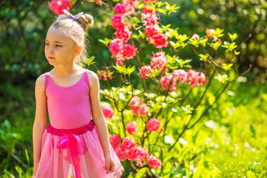 Caucasian Girl in Pink Dress Posing in the Pink Blossom Summer Garden