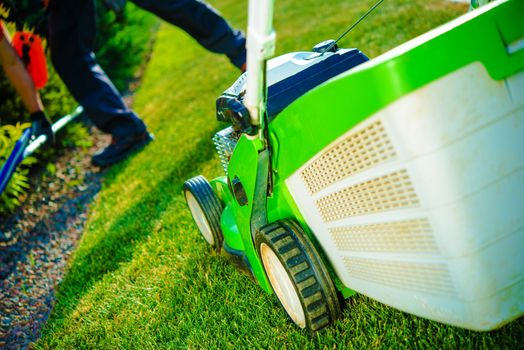 Summer Lawn Mowing. Green Lawn Mower and Working Gardener. Gardening Theme.