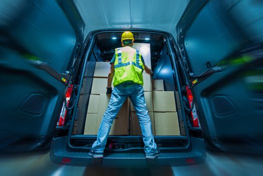 Large Heavy Duty Cargo Van Loading by Men in Yellow Helmet. Shipping and Logistics Theme.