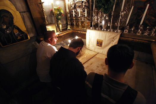 Pilgrims pray at the tomb of Jesus in the Church of the Holy Sepulchre, traditional site of the crucifixion, burial, and resurrection of Jesus, on October 01, 2006.