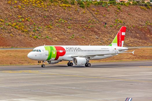 Funchal, Madeira, Portugal - May 30, 2013: At the airport of Madeira (Aeroporto Madeira) - an airplane Airbus A320 from TAP Portugal Airline on runway.