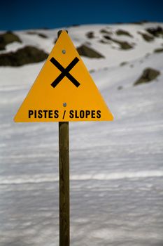 A sign warning for slopes in a ski domain