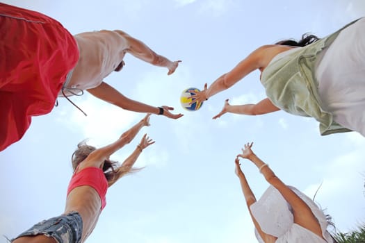 Group of young people playing volleyball outdoors