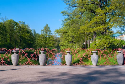 Bridge with stone vases on the ditch in park of Pushkin near Sankt-Petersburg summer sunny day