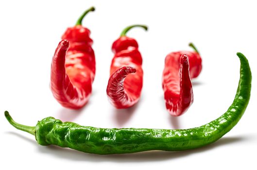Green and red hot chili peppers isolated on white background, food close-up.