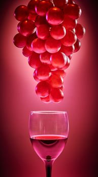 Ripe red branch of grapes with glass of wine on red background