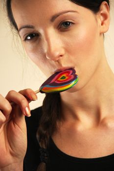 Girl licking a coloful lollipop.